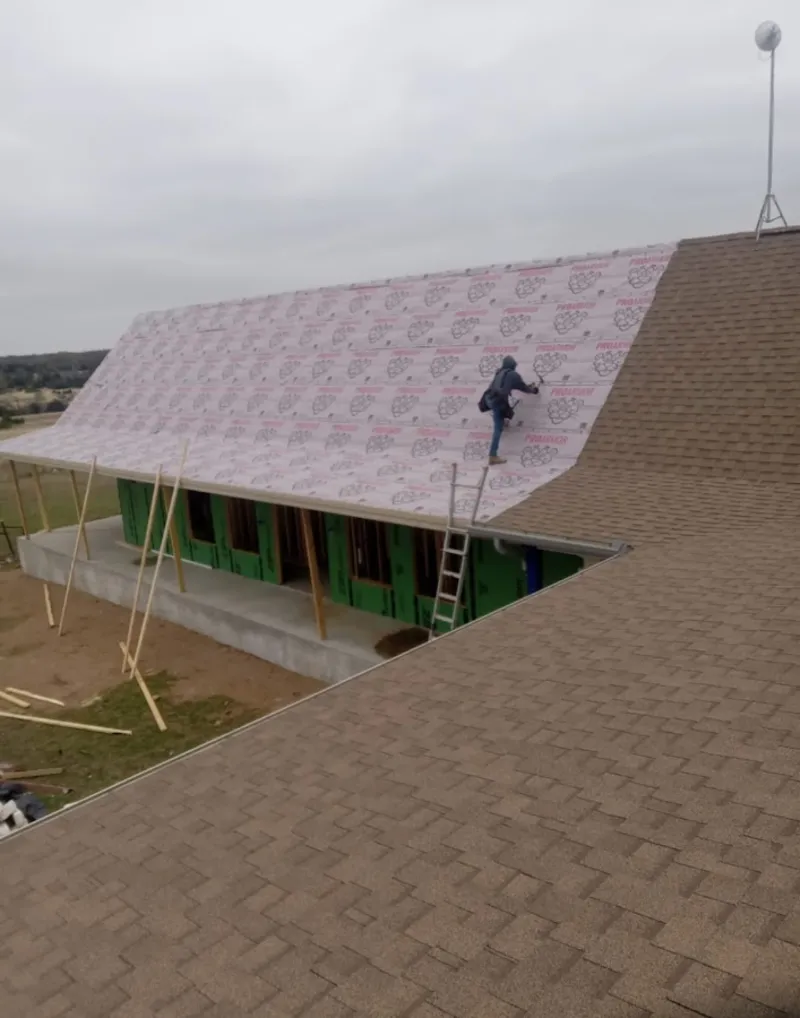 Worker preparing underlayment for a metal roof installation in Ocean Springs